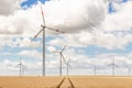 Scenic landscape view of wheat field harvest and big modern wind turbine mill farm against beautiful clouds blue sky Royalty Free Stock Photo