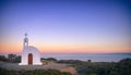 Scenic landscape with a white church and aegean sea at sunset. Royalty Free Stock Photo