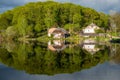 Wooden house near lake, forest reflected on water Royalty Free Stock Photo