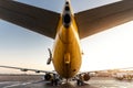 Scenic low angle pov rear bottom view of big modern passenger aircraft back tail on ground parking against blue orange Royalty Free Stock Photo