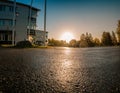 Scenic low level view on rising Sun over empty parking lot close to typical office building, early morning, clear sky with Sunrise Royalty Free Stock Photo