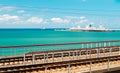 Scenic marine background with azure sea, white ship, harbor and railroad