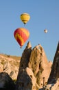 Scenic morning landscape view of flying hot air balloons over amazing cave houses in shaped sandstone rocks near Goreme Royalty Free Stock Photo