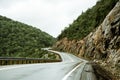 Scenic mountain winding road after the rain. Wet road and steep hills