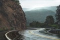 Scenic mountain winding road after the rain. Wet road and steep hills