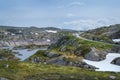 Scenic Norwegian landscape with rocks, lake and curved mountain road. Royalty Free Stock Photo
