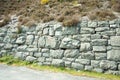 Old stone wall by a roadside.