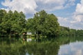 Scenic outdoor image of a tranquil lake surrounded by lush foliage and camping cabins