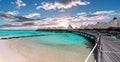 Scenic panoramic landscape view of luxury overwater bungalows at the beach and lagoon during sunset in Moorea, French Polynesia. Royalty Free Stock Photo