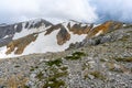 Scenic panoramic view of idyllic rolling hills landscape with blooming meadows and snowcapped alpine mountain peaks in Royalty Free Stock Photo