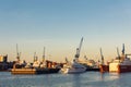 Scenic panoramic view large modern luxury super yacht at maintenance service against construction cargo cranes at dry Royalty Free Stock Photo