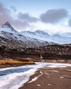 Scenic photo of southern Iceland with iced river and mountains with snow in the background