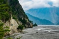 Scenic photo of two trekkers walking in the Gandaki river valley in the Annapurna Circuit, Himalayas