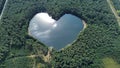 the heart shaped lake is surrounded by trees and a lot of clouds Royalty Free Stock Photo