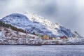 Scenic Picturesque Lofoten Islands with Colorful Small Houses Against Snowy Mountains in Background At Spring Time