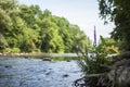 Scenic River flowing through Nature and watering and nourishing Plants and purple Wild Flowers Royalty Free Stock Photo