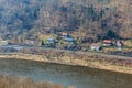 Scenic riverside village with railway and forested hills in early spring Royalty Free Stock Photo