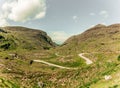 Scenic road of Gap of Dunloe, a narrow mountain pass in county Kerry, Ireland on a sunny day Royalty Free Stock Photo