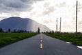 Scenic Road in a small town with Mountain in the Background during a dramatic sunny and cloudy evening