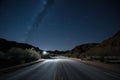 scenic road trip through the night, with stars and moon visible in the sky Royalty Free Stock Photo