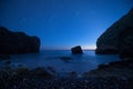 Scenic rocky seashore at sunset under the stars.