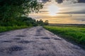 Scenic rural landscape with rural broken dirt road at sunset Royalty Free Stock Photo