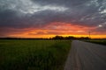 Scenic rural landscape with rural broken dirt road at sunset. Royalty Free Stock Photo