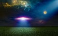 Scenic sci-fi image - ufo inspect green grass field with bright spotlight in dark night sky. Nebula and full moon in starry sky Royalty Free Stock Photo
