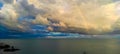 Scenic seascape after the rain with a rainbow basin between a cloudy blue sky over the sea horizon.