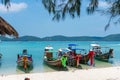 Scenic shot of a beach with sailboats in the shallow waters of the ocean in Krabi, Thailand