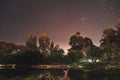 Scenic shot of a beautiful landscape reflecting on the pond water on a starry night background Royalty Free Stock Photo