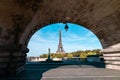 Scenic shot of the Eifel tower in Paris, France, seen through an arch of a bridge