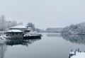 Scenic shot of houses on the coast of a lake in winter surrounded by lush forestr Royalty Free Stock Photo