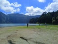 Scenic shot of a lake and mountains in a summer park and people admiring the view Royalty Free Stock Photo