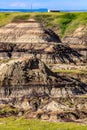 Scenic shot of a valley in Drumheller with a layer of green grass on the eroded surface