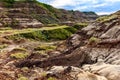 Scenic shot of a valley in Drumheller with a layer of green grass on the eroded surface