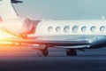 Scenic side close view modern luxury expensive private jet plane parked airport taxiway hangar warm colorful dramatic Royalty Free Stock Photo