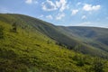 Scenic skyscape with blue sky full of windy clouds, and beautiful green mountains. Carpathians, Ukraine Royalty Free Stock Photo