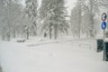 Scenic stormy winter view of a white snowy field with a traffic pole with signs