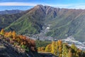 Scenic sunny autumn blue sky aerial mountain landscape of Krasnaya Polyana village in Sochi, Russia with Achishkho peak on backgro