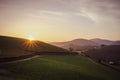 Scenic sunrise over mountains filtered. Mountain road in the morning toned. Beautiful morning with sun rays over green hills. Royalty Free Stock Photo