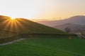 Scenic sunrise over mountains filtered. Mountain road in the morning toned. Beautiful morning with sun rays over green hills. Royalty Free Stock Photo