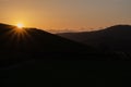 Scenic sunrise over mountains filtered. Mountain road in the morning toned. Beautiful morning with sun rays over green hills.