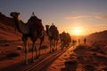 Scenic sunset desert landscape with trekking camels and sun setting over sand dunes Royalty Free Stock Photo