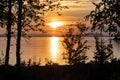 Scenic Sunset over Umea river Mountains, clear summer sky with some clouds highlighted by orange red Sun. Blurry foreground with Royalty Free Stock Photo