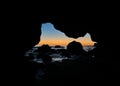 Scenic sunset through a sea cave, capture with the cave's silhouette against the seascape Royalty Free Stock Photo