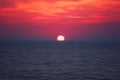 Scenic sunset seascape with sea, sun and amazing scarlet cloudy sky, travel background Royalty Free Stock Photo