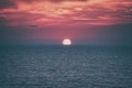 Scenic sunset seascape with sea, sun and amazing scarlet cloudy sky, travel background Royalty Free Stock Photo