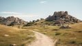 A scenic trail leading through a grassy landscape towards rocky hills under a clear blue sky Royalty Free Stock Photo