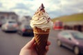 Scenic treat hand holds vanilla ice cream dipped in hot chocolate